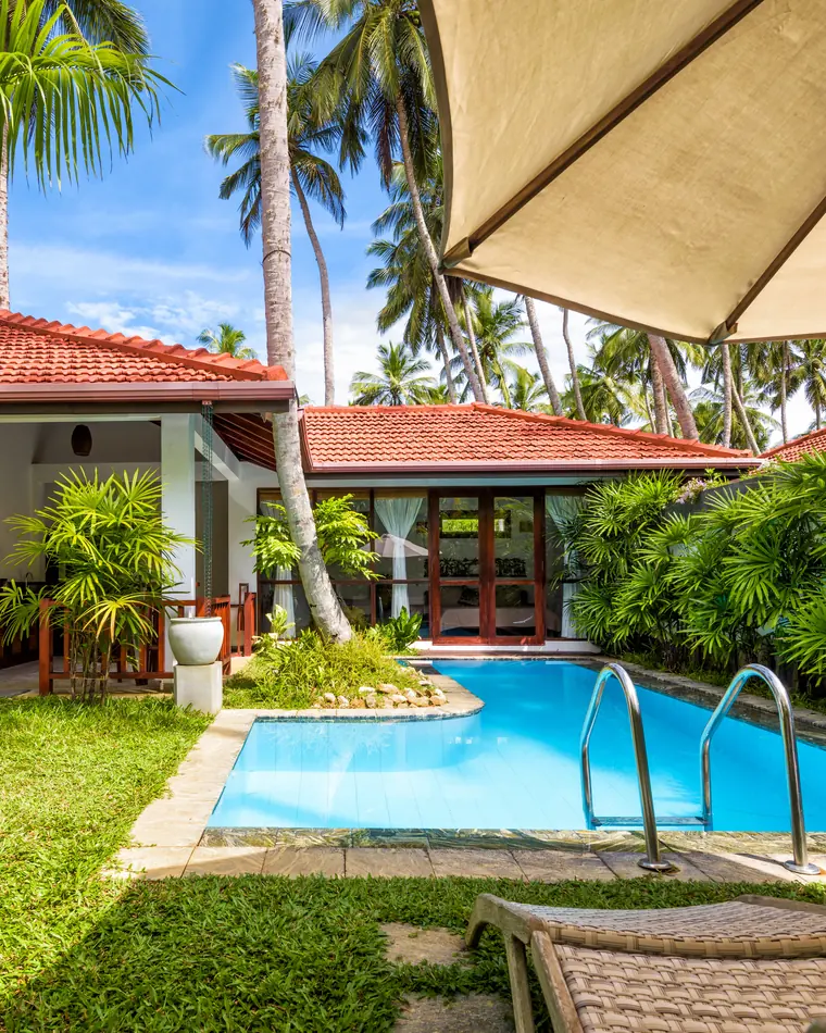 Photo d’illustration : villa de plain-pied avec piscine et jardin tropical, lieu non précisé